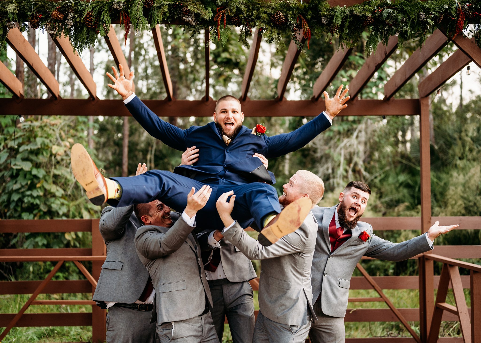 Groomsmen tossing the groom in the air