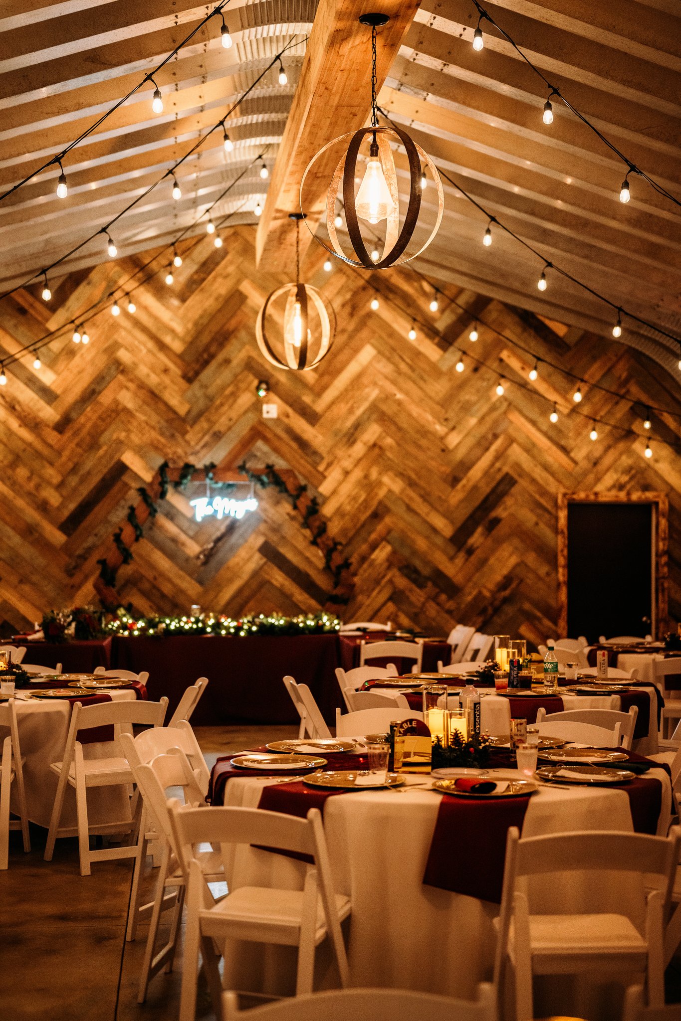 Barn reception hall with string lights and set tables