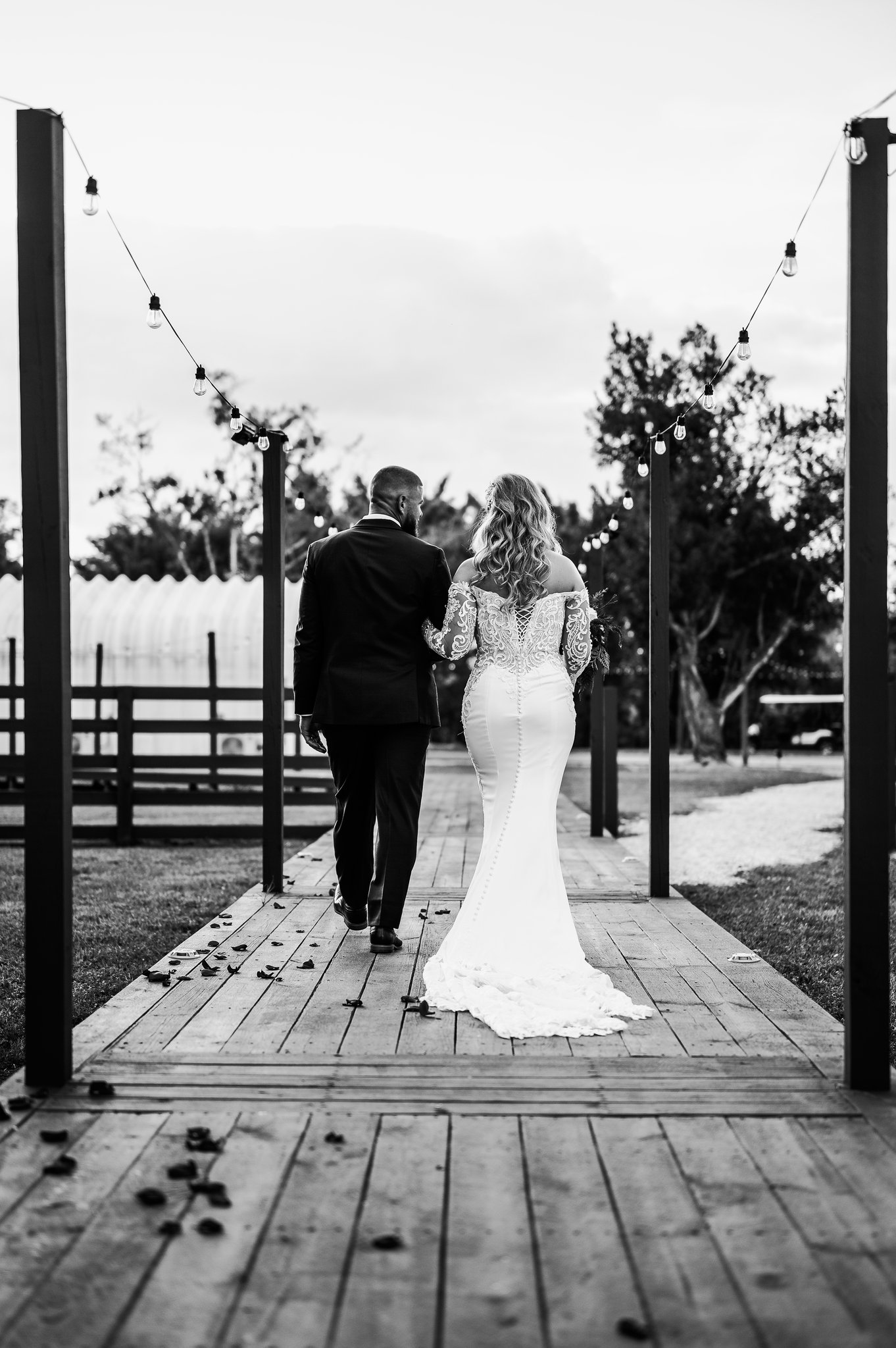 Couple walking the string-lit boardwalk at night