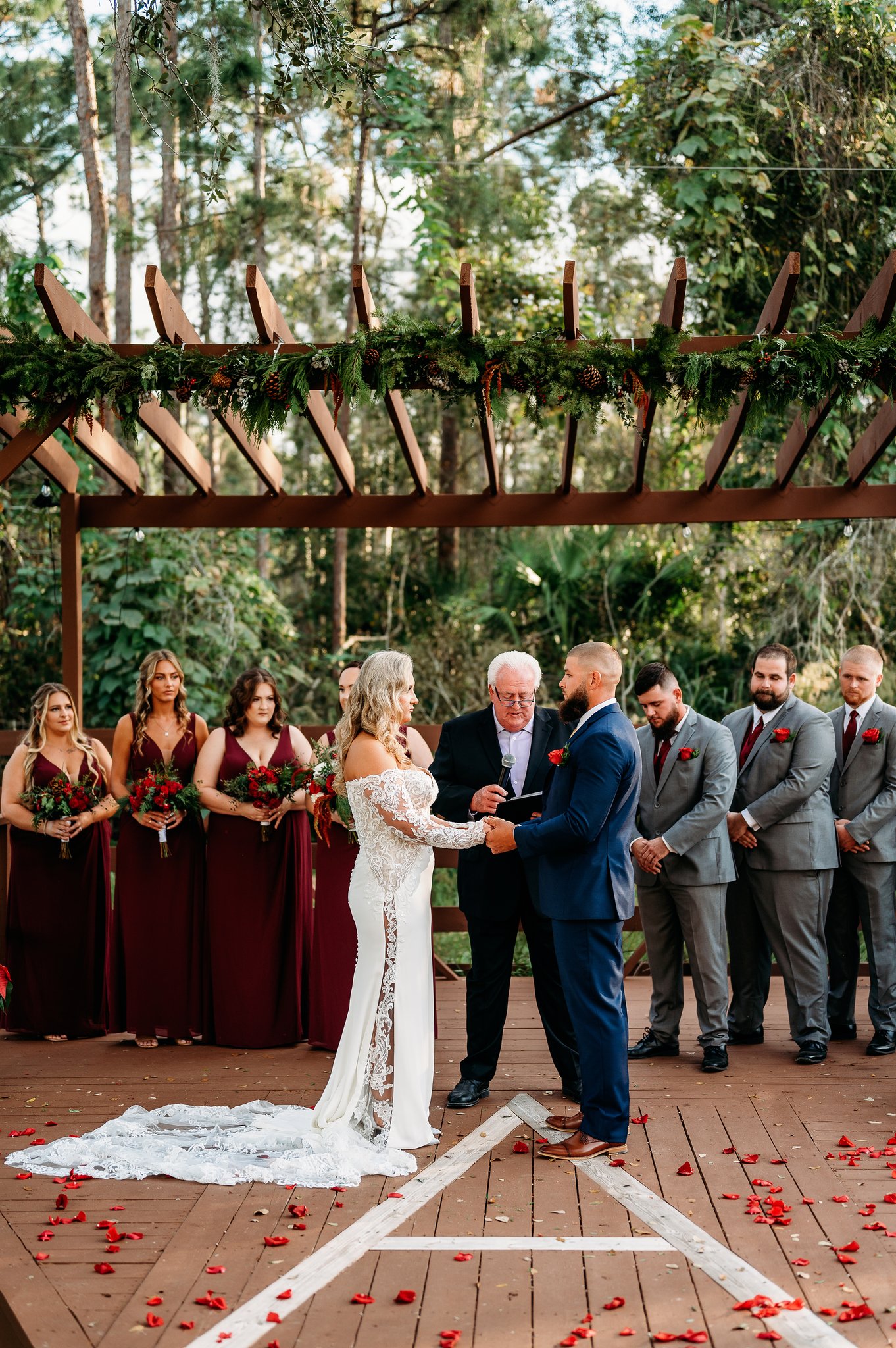 Vows in progress under the garland-draped pergola