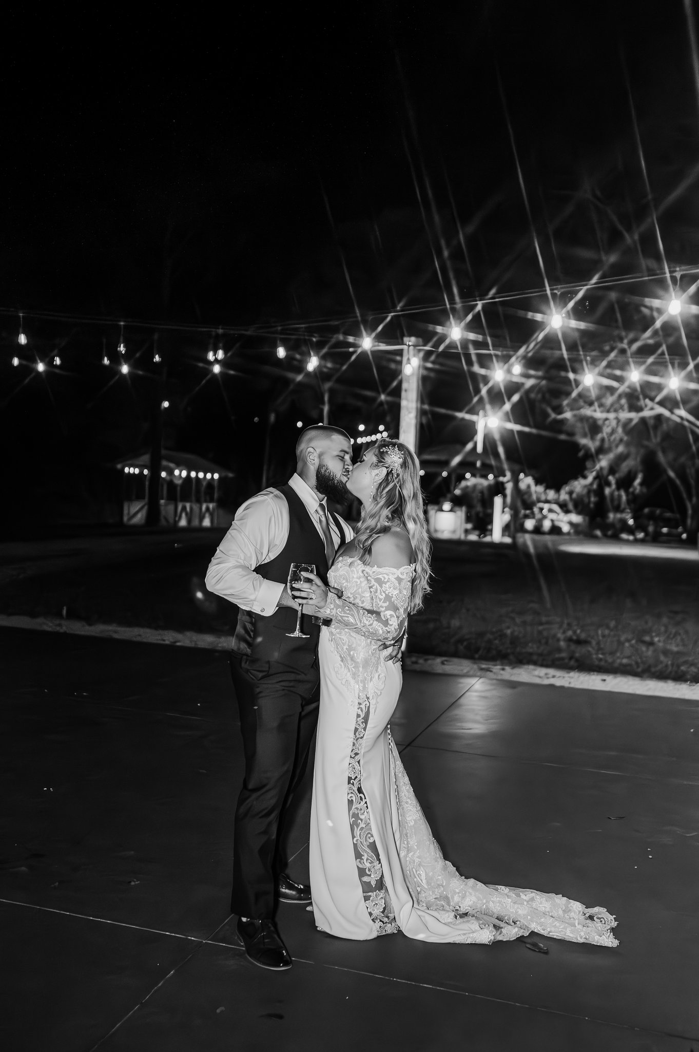 Couple alone on the dance floor beneath crisscrossing string lights
