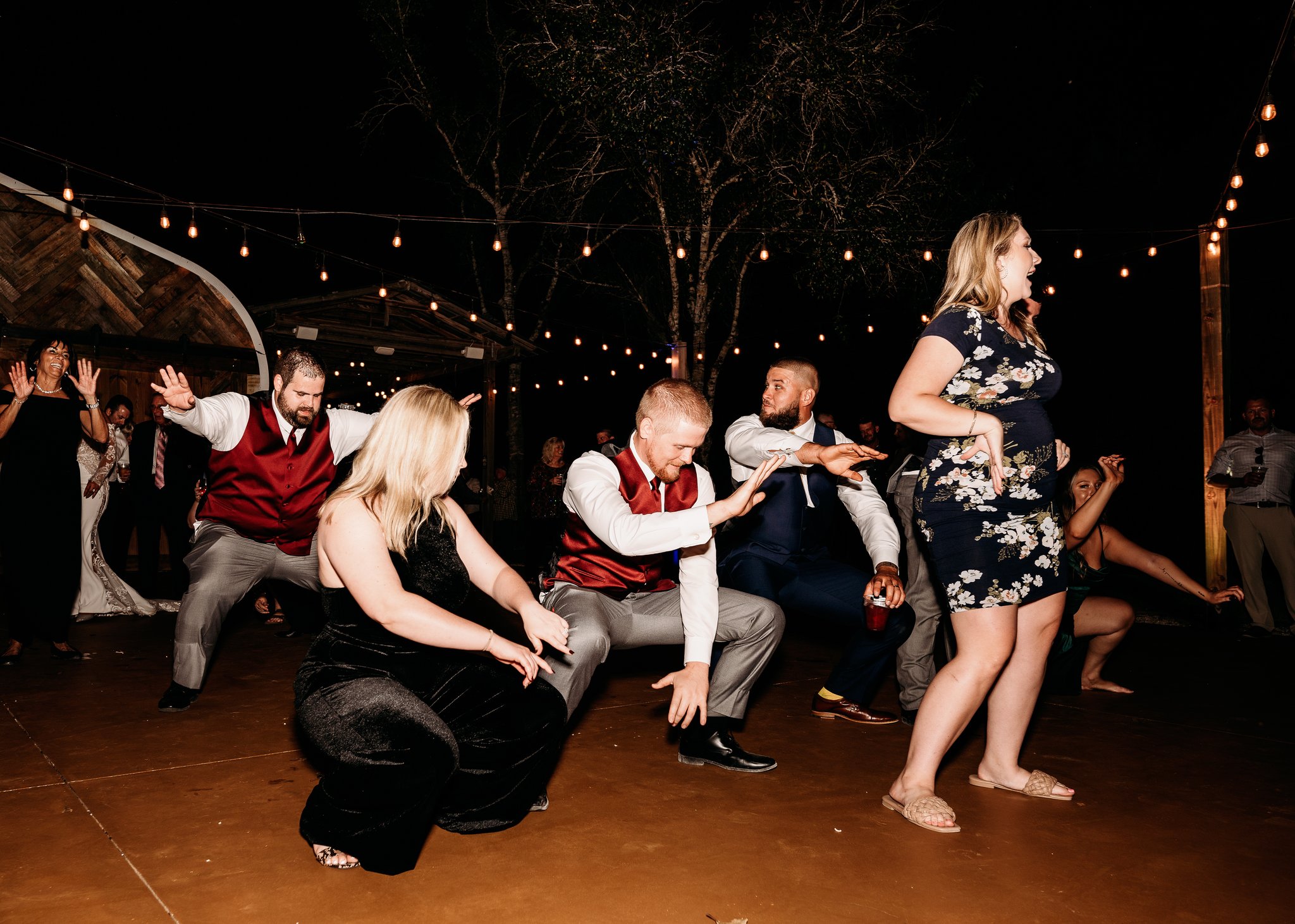 Guests dancing under string lights at night
